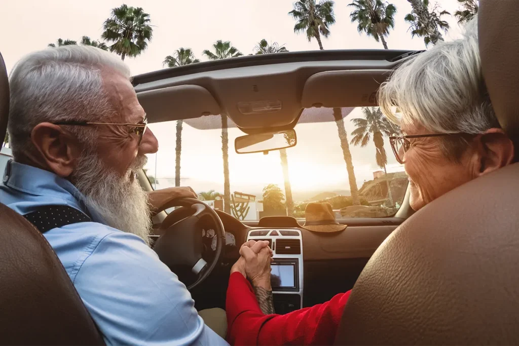 retired couple cruising around in convertable