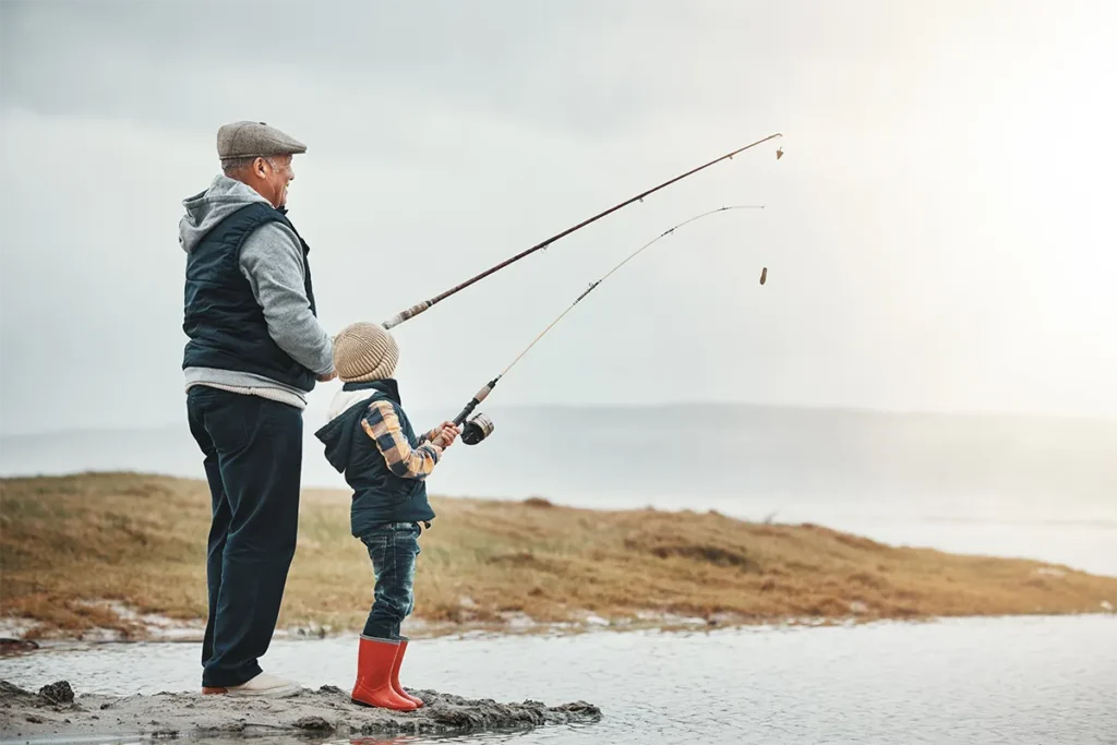 older man fishing with his grandson